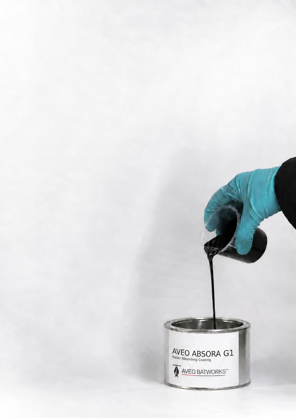 AVEO ABSORA G1 radar-absorbing coating being poured from a mixing cup into its tin