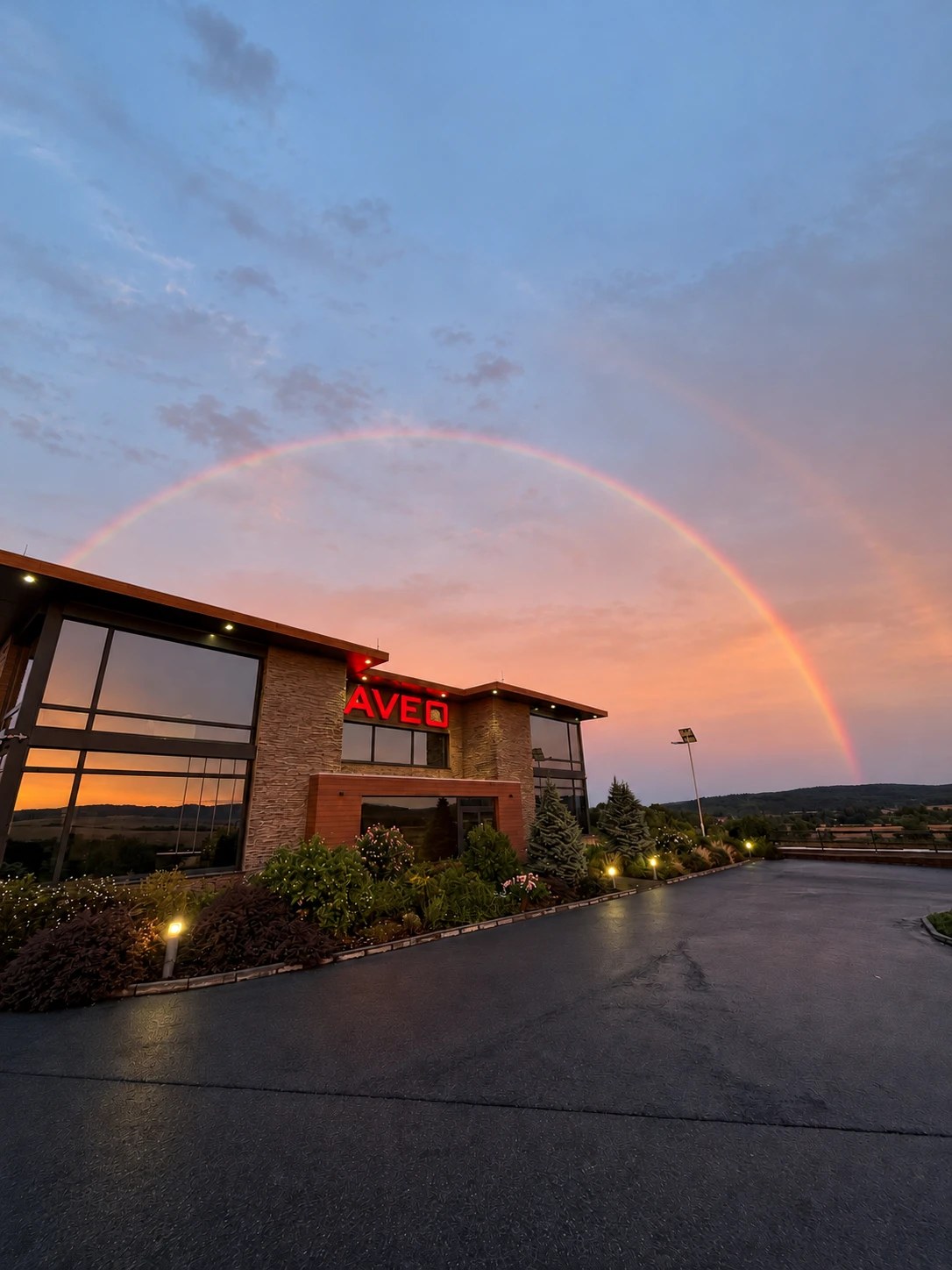 Aveo Engineering headquarters under a double rainbow at dusk