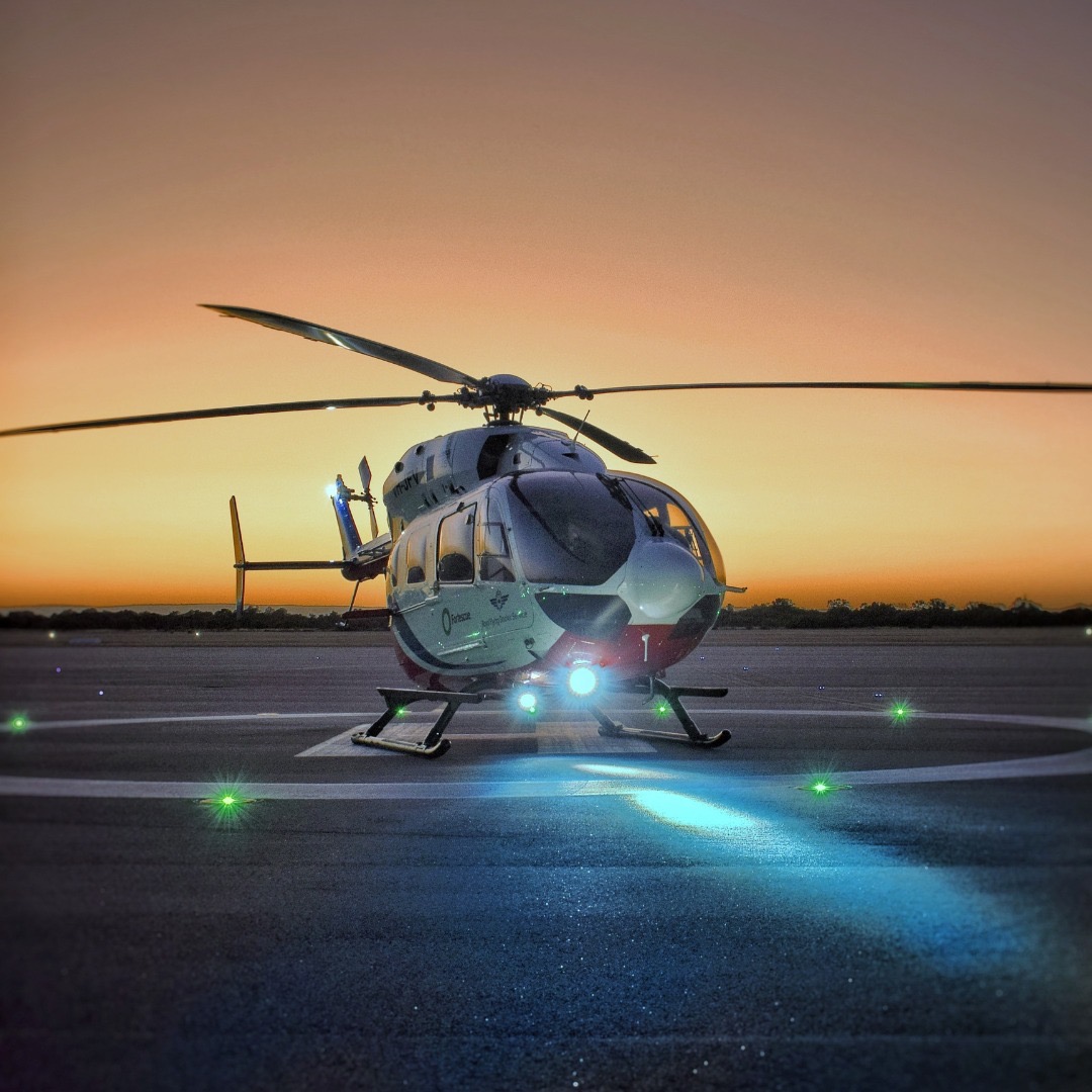 RFDS rescue helicopter with Aveo Sapphire lighting on a helipad at sunset